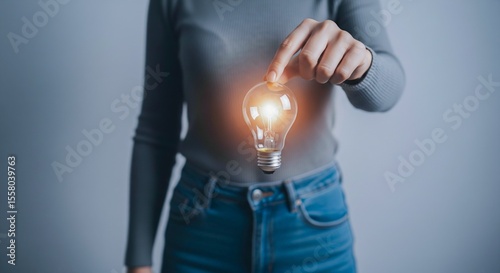 Idea Generation - Woman Holding a Glowing Lightbulb Symbolizing Innovation & Inspiration