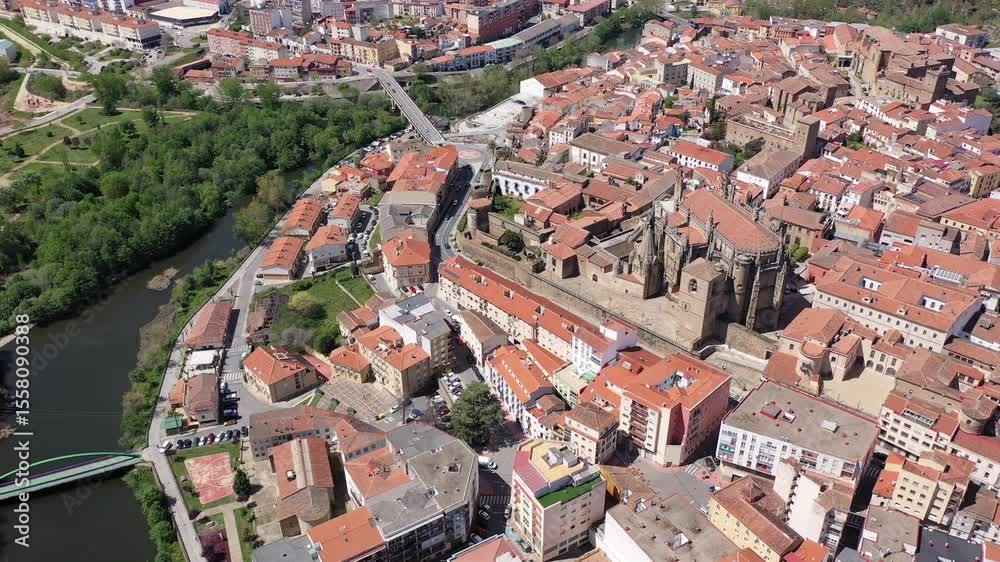  Bird's eye view of residential buildings with tiled roofs, Jerte River and cathedral in Plasencia, Extremadura, Spain. 
