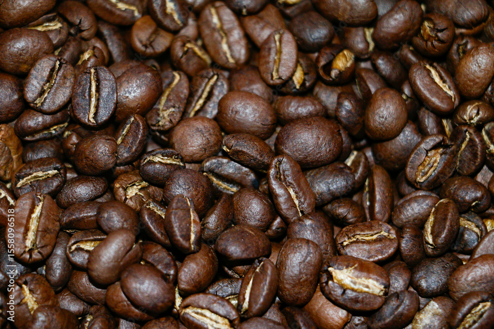 Fototapeta premium Top view background of aromatic brown coffee beans scattered on the surface.