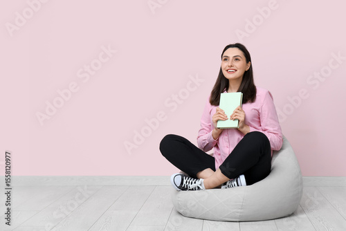 Young woman sitting on pouf...