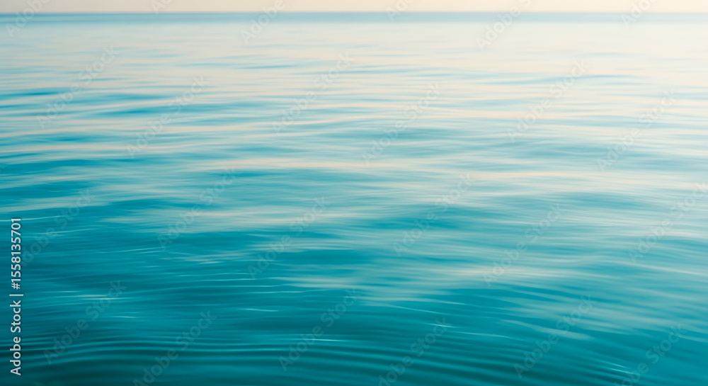 Naklejka premium Gentle blue water waves glisten, reflecting sunlight in a serene expanse of ocean, sea, or lake creating a peaceful, calming water background.
