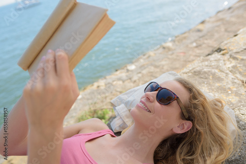 woman reading a book on the beach