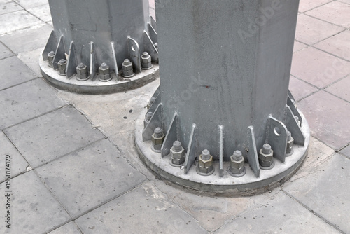 two steel column base with anchor bolts on concrete tile pavement