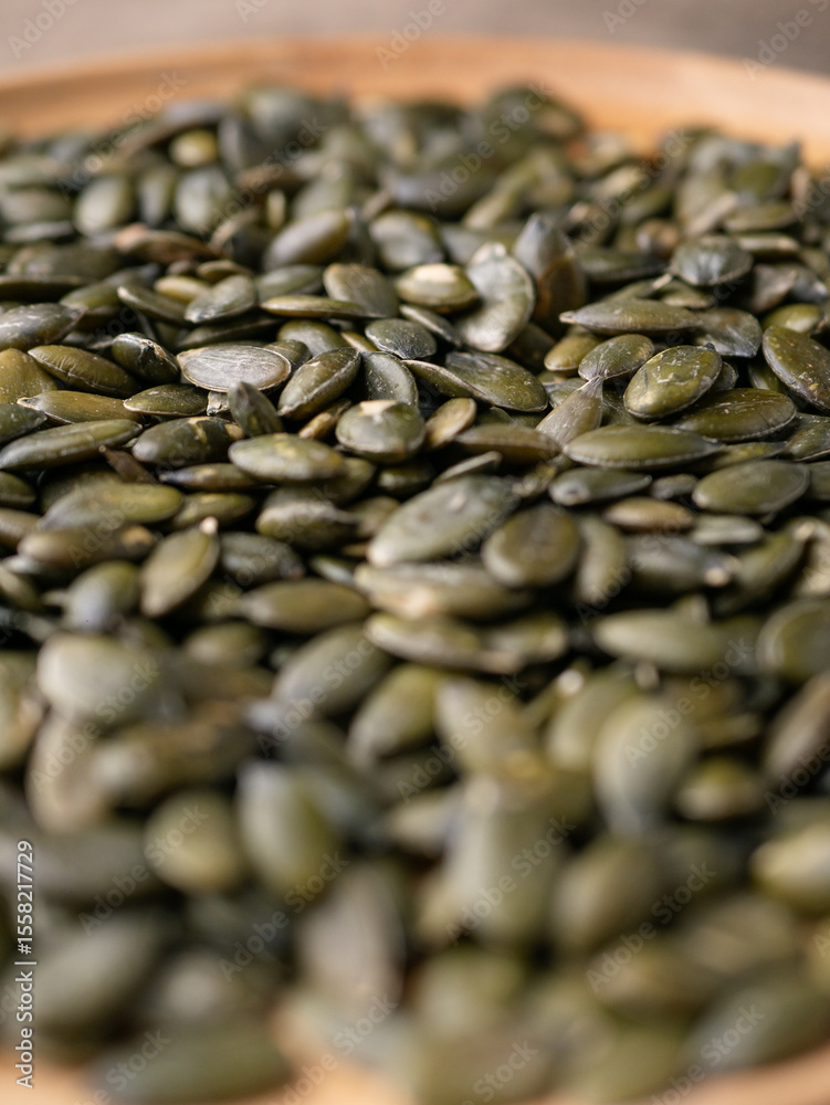 Obraz premium Peeled dry pepita pumpkin seeds background.