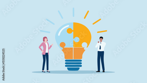 Two business people collaborating to create a bright new idea represented by a puzzle lightbulb