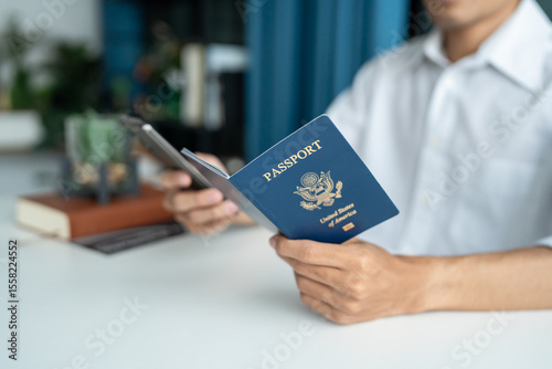 Hand Man Online booking and buying plane tickets using laptop phone and credit card Planning trip travel vacation with passport and ticket.