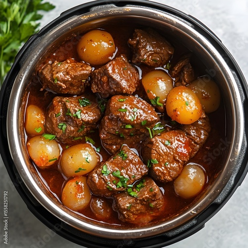 Semur daging sapi dan bawang mutiara yang kaya rasa, dimasak dalam pressure cooker. Hidangan yang lezat dan empuk, siap disajikan. beef stew with vegetables