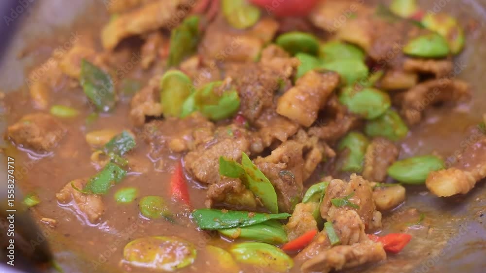 Spicy stir fried pork with Cluster Bean (Bitter Bean or stink beans) popular southern Thai food, Spicy stir fried chicken with Cluster Bean (Bitter Bean or stink beans).Thai southern food