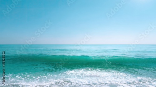 Isolated single wave forming clean barrel over emerald green sea with distant horizon