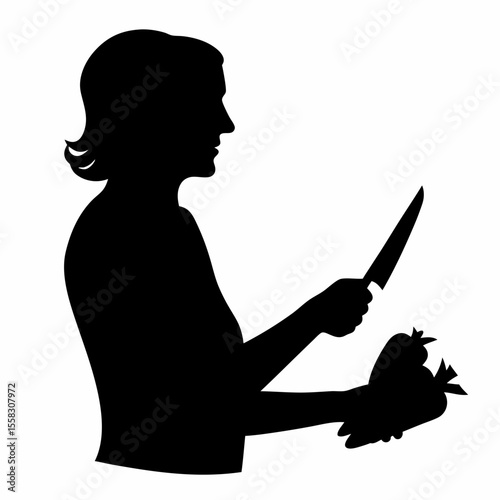 Silhouette of woman cutting vegetables with a knife in her hand preparing a healthy meal at home kitchen