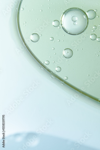 A vertical macro shot of abstract oil bubbles suspended in liquid, showcasing smooth texture and clarity. Ideal for beauty product visuals, skincare branding, and cosmetic design.