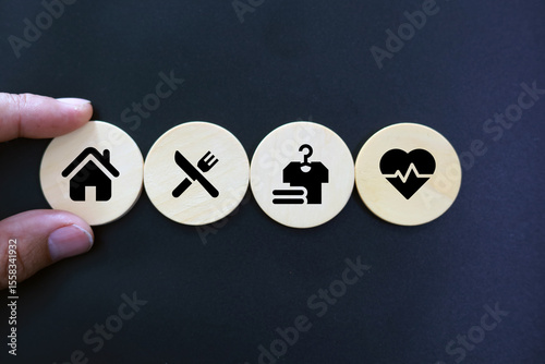 Obraz na plátně wooden cube with icons of food, Clothing, housing, medical bag, four basic human needs concepts