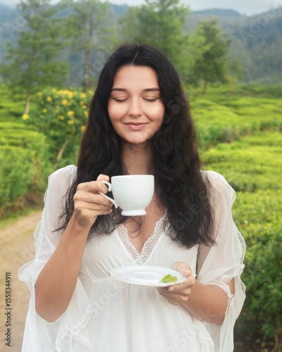 Woman Drinking Tea And Smiling In Bright Green Tea Field Landscape