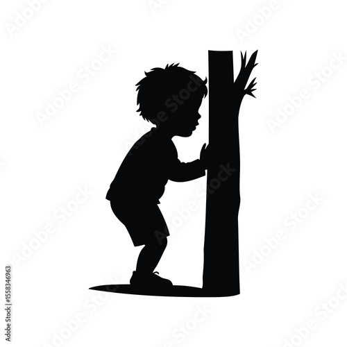 Silhouette of a young boy playing hide and seek behind a tree
