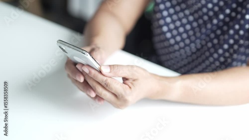 senior  Asian woman holding a smart phone use mobile phone at home
