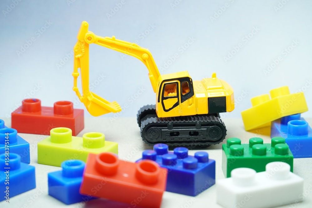 Fototapeta premium Mini toy of heavy truck and mini figure at table with blurred background. Toy photography concept. Industrial conceptual design.