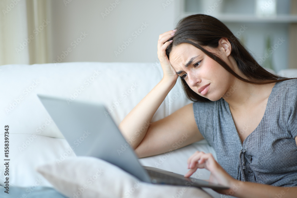 Stressed woman checking bad news on personal computer Stressed woman checking bad news on personal computer