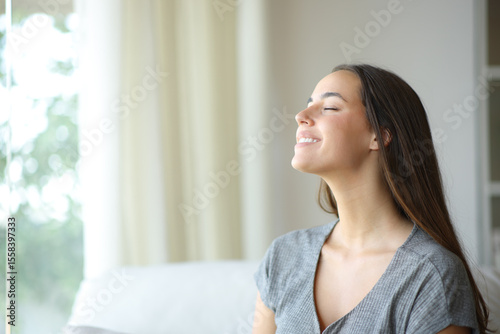 Happy woman breathing fresh air in a living room Free Download Happy woman breathing fresh air in a living room - GFXLoad