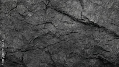 Detailed black and white texture of cracked dark gray granite rock surface for design elements