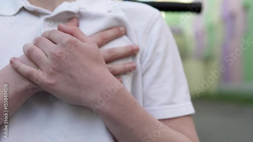 Boy feels sharp pain in heart after school bullying. Concepts of heart failure, stress and panic attack.