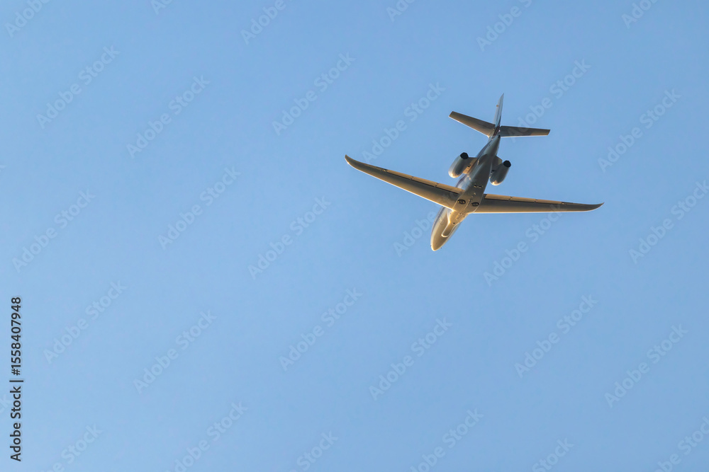 Private jet flying in the blue sky over Hostivice, Czechia Private jet flying in the blue sky over Hostivice, Czechia