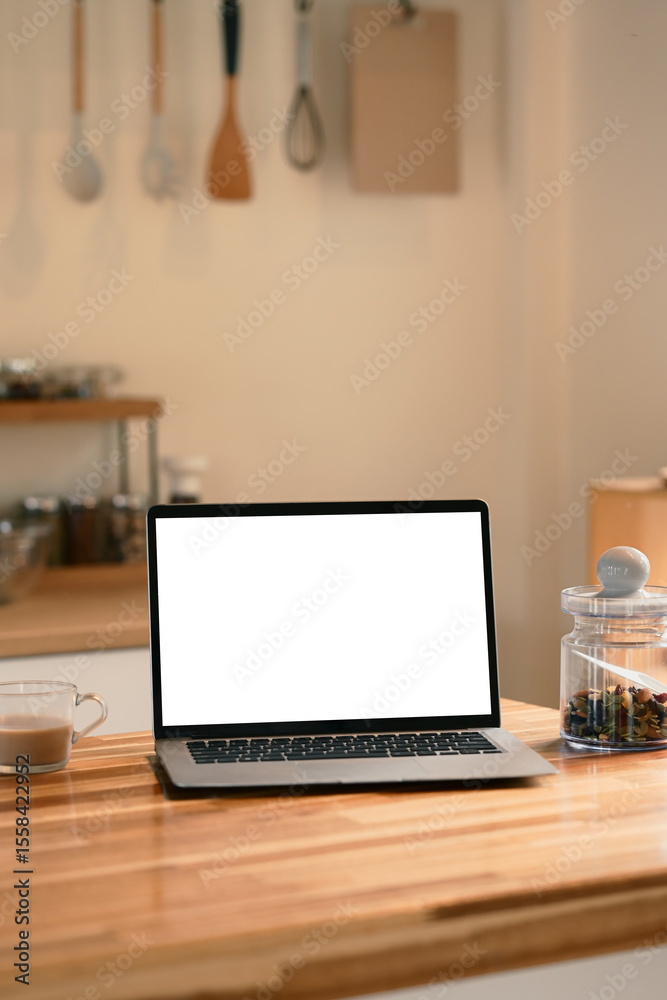 Naklejka premium Bright kitchen with a laptop, coffee, and a jar of dried fruit and warm natural light