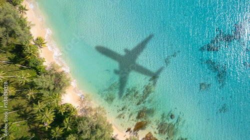 Aerial view of shadow passenger plane silhouette and sandy beach blue sea with waves at sea beach summer vacation sea travel concept	