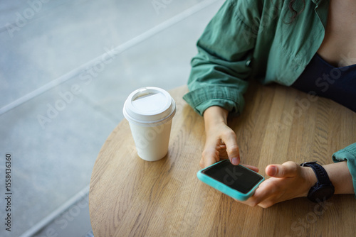Woman enjoying coffee and smartphone at a cafe