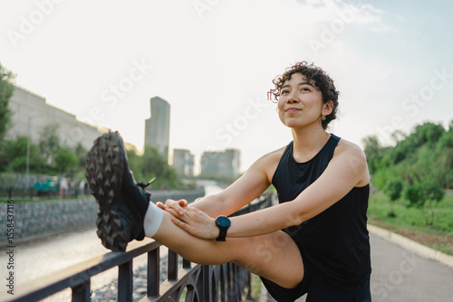 Young woman stretches outdoors in urban setting
