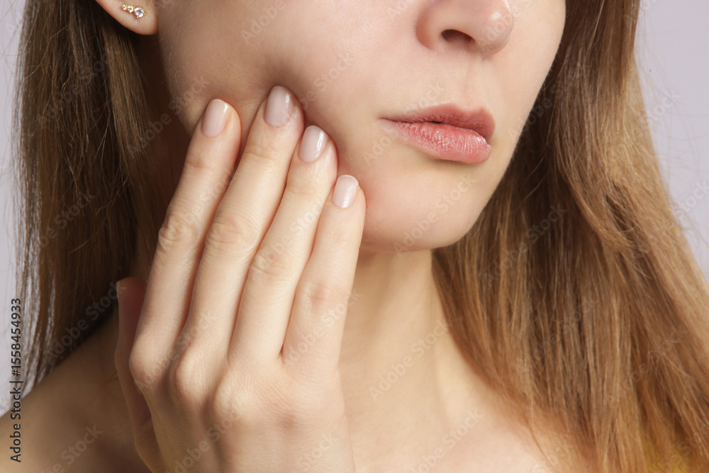 Fototapeta premium Studio shot of young woman with tooth pain, close up