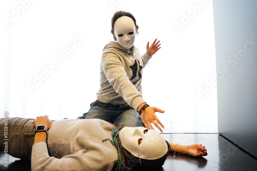 Teenagers in masks performing in drama class