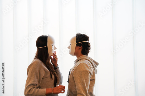 Teenagers in drama class wearing theatrical masks