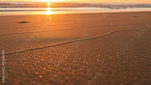 Golden hour beach sand texture close up at sunset nature background