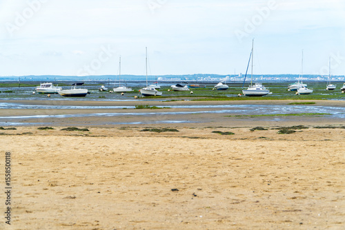 Boats stranded on sandy shore at low tide