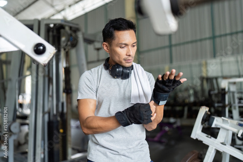 Gym Preparation. Man adjusting wrist wraps before workout.