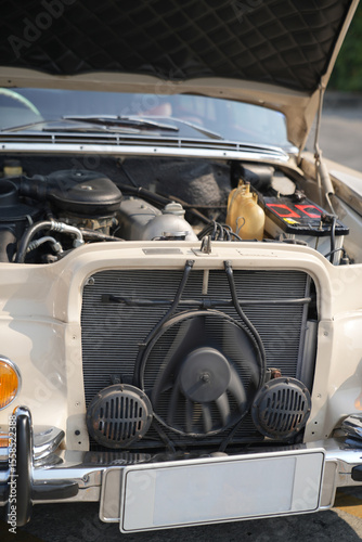 The engine and battery compartment of a classic car, with its detailed mechanical and electrical components, the vintage engineering powering the vehicle.