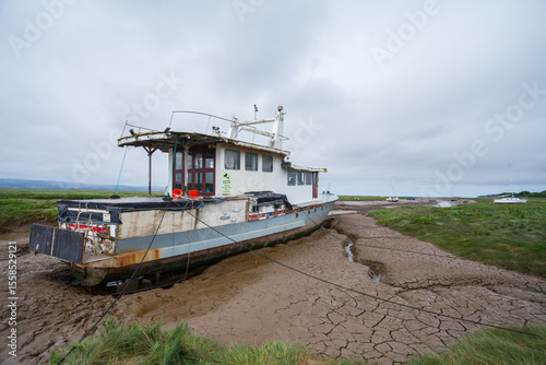 Fototapet Abandoned vessel – a lonely boat marooned in a desolate tidal estuary