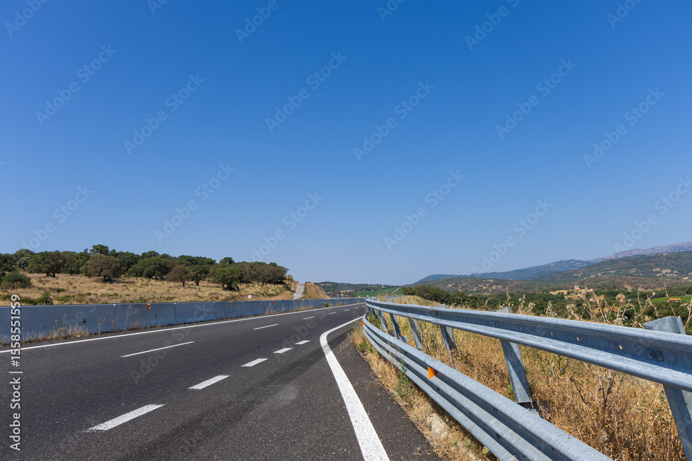 empty road on the island of Sardinia Italy in a beautiful sunny day with blue sky and white clouds in the background. empty road on the island of Sardinia Italy in a beautiful sunny day with blue sky and white clouds in the background.