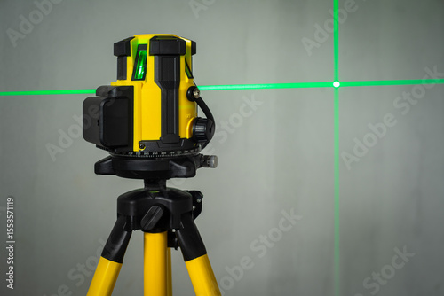 laser level machine equipment with the green laser lines shown on concreat wall at the front