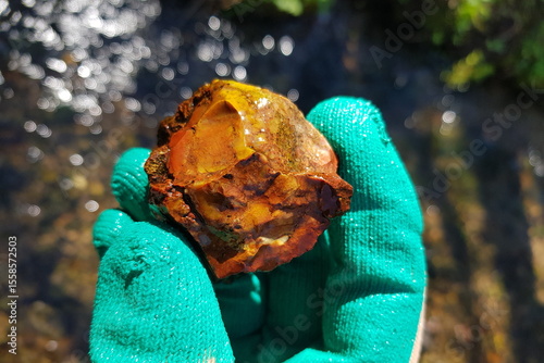 Beautiful brightly colored stone found in a stream, field photo on a phone