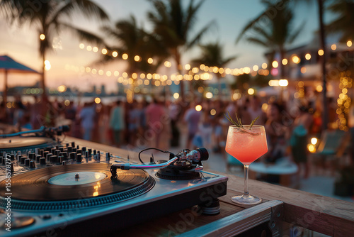 Dj playing music at a beach party with refreshing cocktail during sunset
