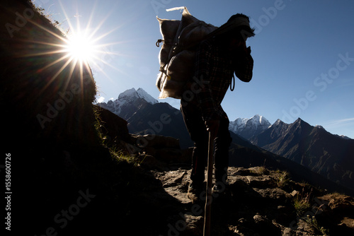 Unrecognizable porter carrying heavy load in Nepal