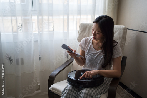 Woman studies robot vacuum instructions at home