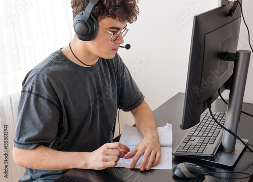 Teenager in Headphones Learning Mathematics Online at Computer Desk — Focused Student Studying at Home with Digital Tools, Remote Education and STEM Concept. Copyspace