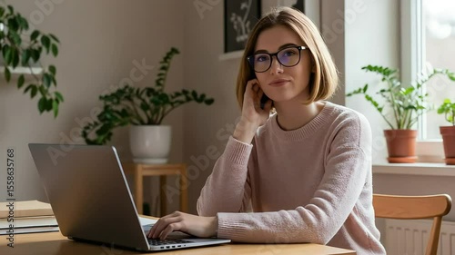 Young woman working on a laptop at home, thoughtfully resting her chin on her hand, surrounded by indoor plants, creating a cozy and productive atmosphere