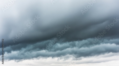 Dramatic storm clouds in deep blue, a sweeping skyscape with dynamic light, nature's raw power on display