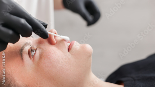 Photos A cosmetologist prepares a young woman's lips before injecting a filler