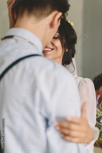 Intimate close-up of a smiling bride during a romantic moment with her partner, expressing love, connection, tenderness, and joy on their wedding day.
