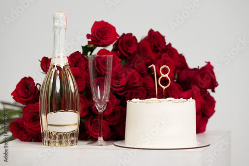 Eighteenth birthday celebration with champagne, cake, and roses.