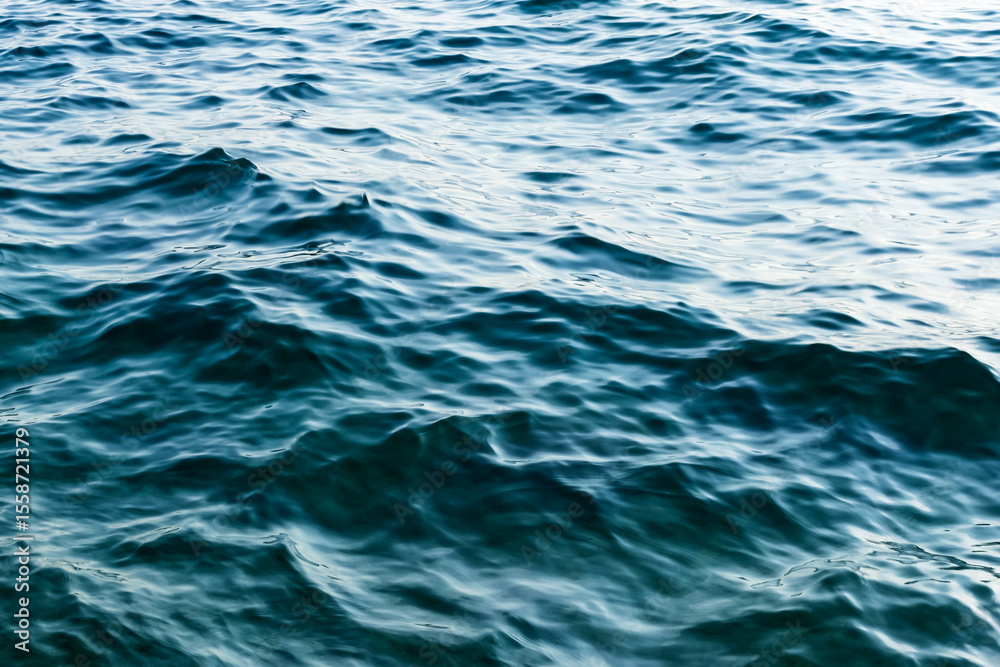 Naklejka premium close up sea water surface. minimalist background with water texture in deep blue colors. gentle sea waves. soft liquid pattern